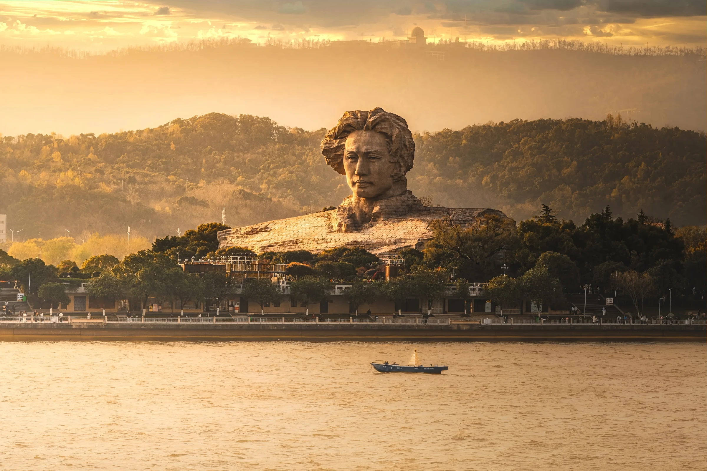 The Young Mao Zedong monument on Orange Isle seen across the Xiang River in warm evening light