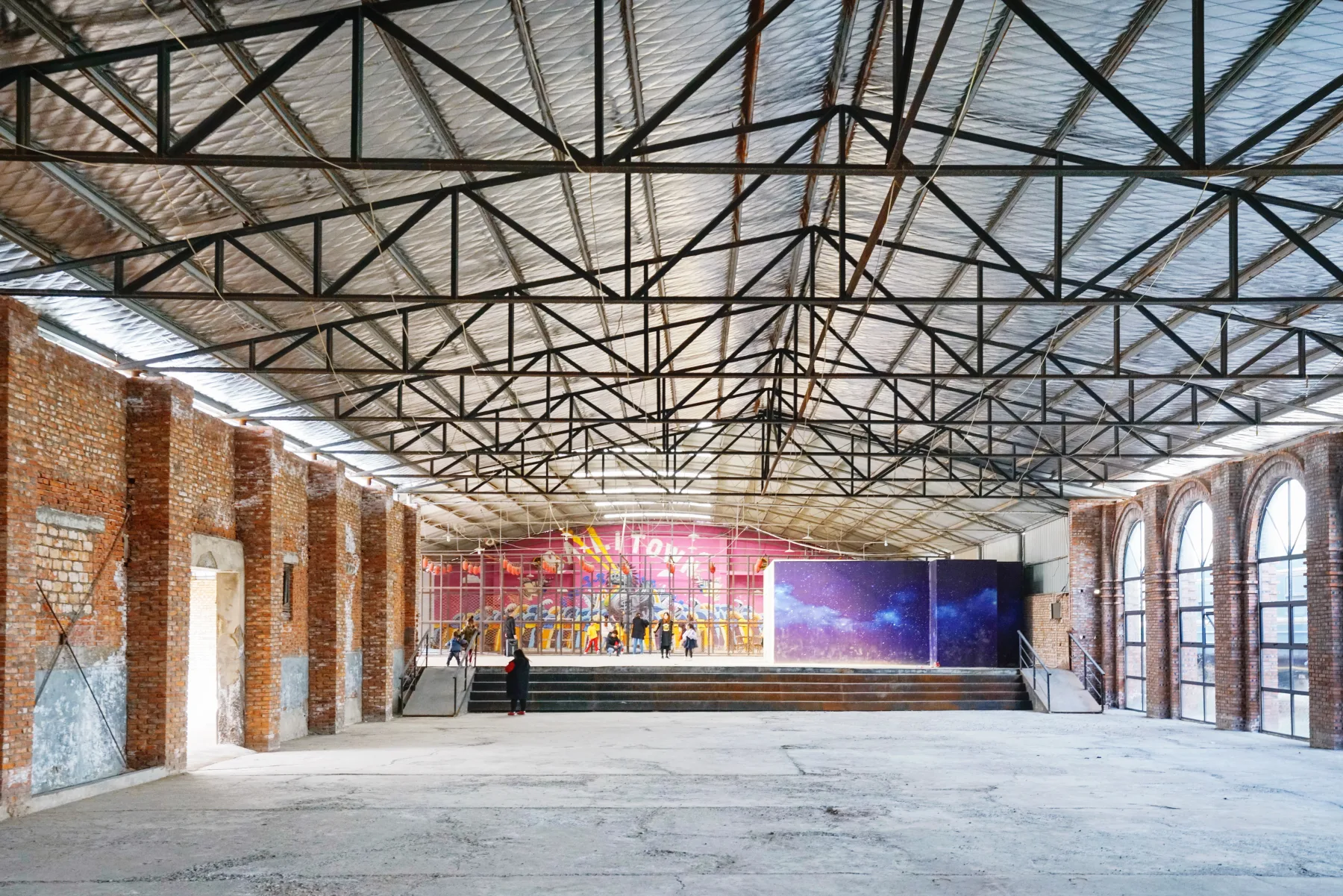 A reused brick factory hall with steel roof trusses and contemporary art in Luoyang's Balitang creative district