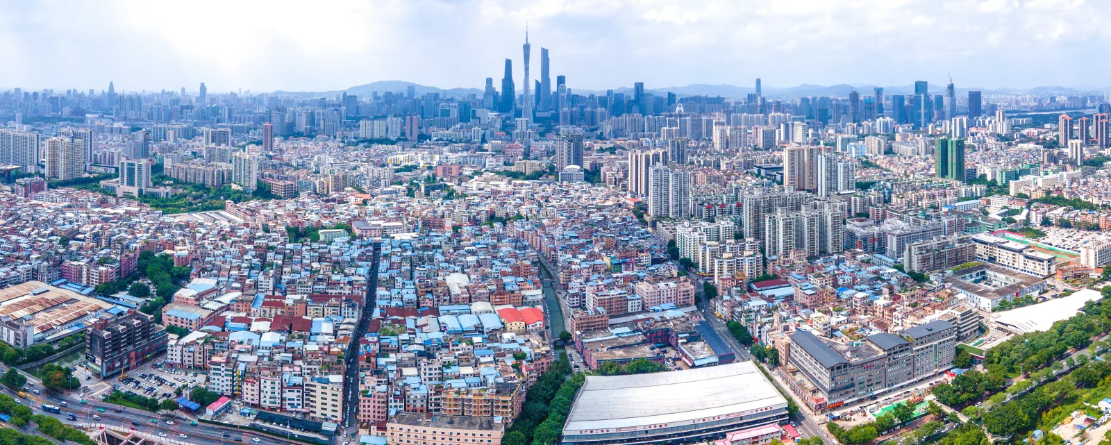 Dense Datang urban village housing stretching toward Guangzhou's modern high-rise skyline